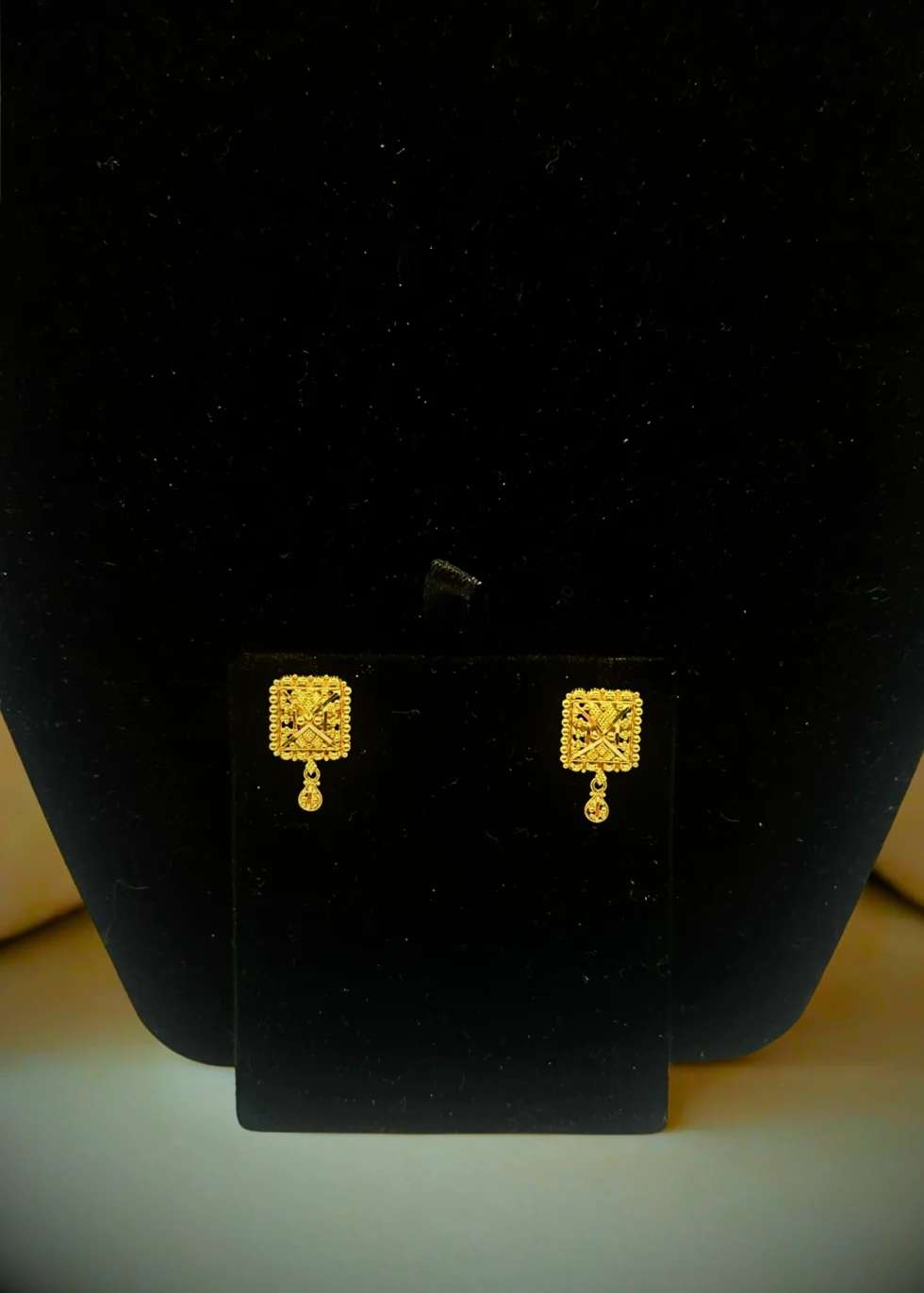 Handcrafted in 4.00 grams of 22KT gold, the Majestic Charm Earrings feature intricate square motifs and delicate gold drops — perfect for festive elegance and timeless style.